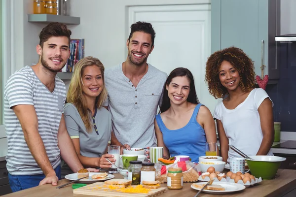 Jóvenes amigos de pie en la mesa —  Fotos de Stock