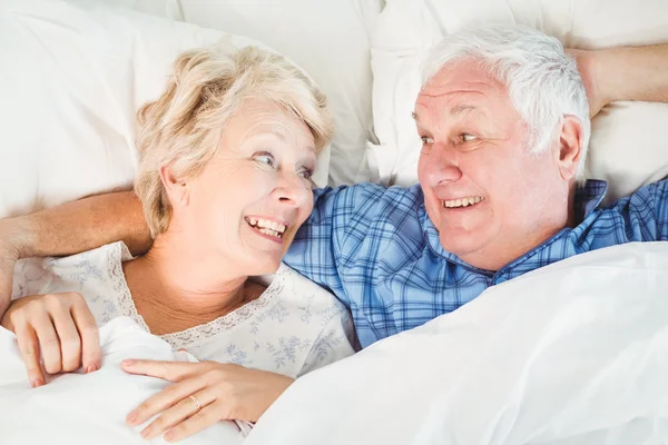 Seniorenpaar liegt auf Bett — Stockfoto