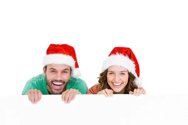 Jovem casal vestindo chapéus de santa — Fotografia de Stock