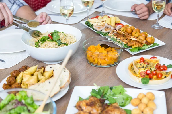 Personas con comida servida en la mesa —  Fotos de Stock