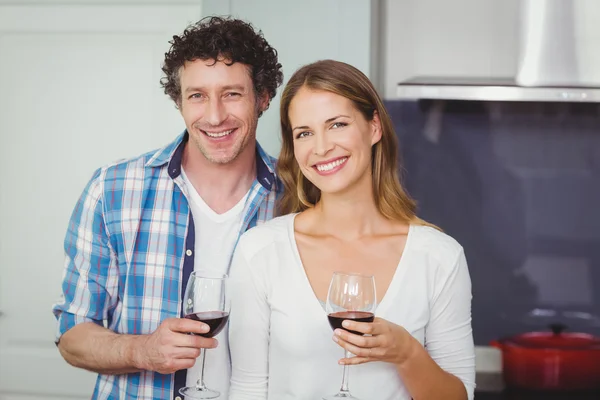 Pareja sosteniendo gafas de vino en la cocina —  Fotos de Stock