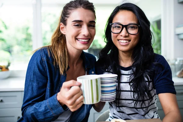 Kvinnliga vänner hålla kaffemuggar — Stockfoto