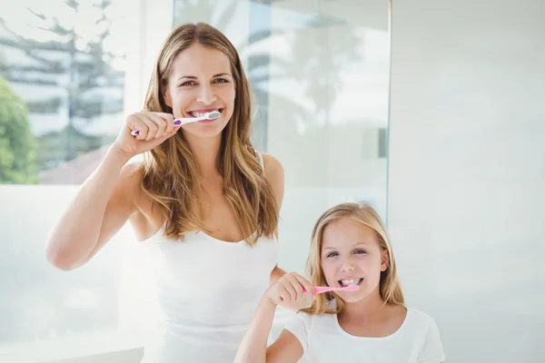 Mãe e filha escovando os dentes — Fotografia de Stock