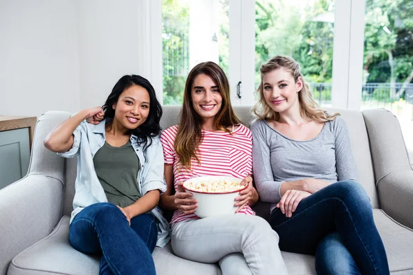 Vriendinnen met popcorn zittend op de Bank — Stockfoto