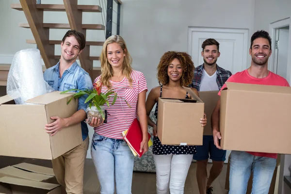 Friends carrying cartons in new house — Stock Photo, Image