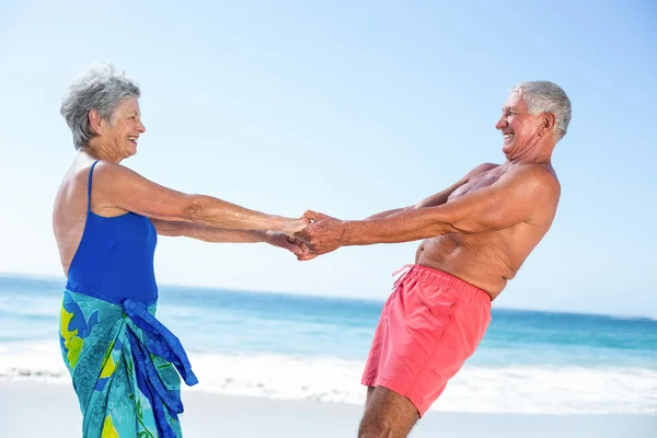 Мила зріла пара тримає руки на пляжі — стокове фото