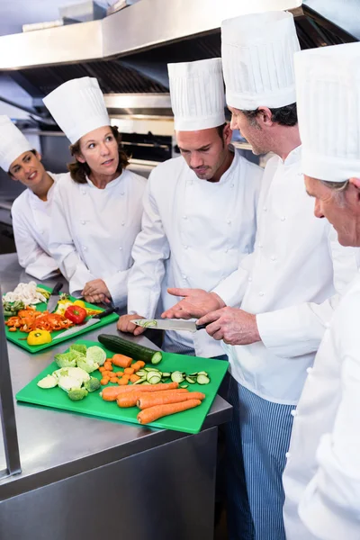 Team von Köchen schneidet Gemüse — Stockfoto