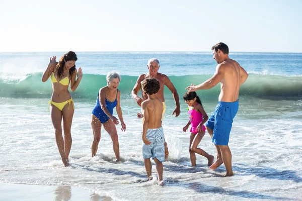 Família feliz brincando com ondas — Fotografia de Stock