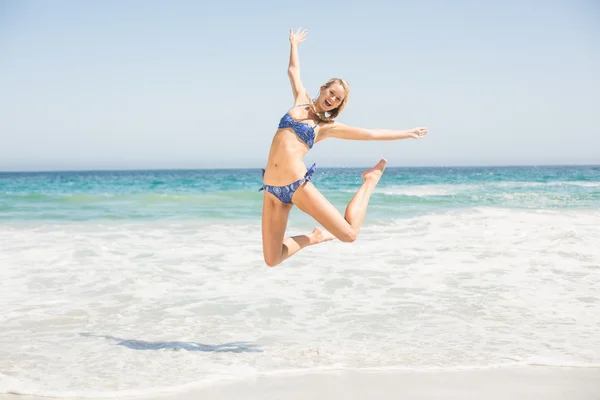 Unbekümmerte Frau im Bikini springt am Strand — Stockfoto
