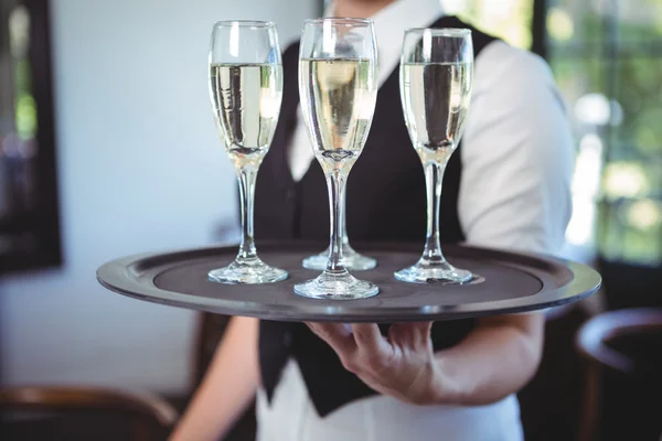 Официантка с подносом флейты шампанского — стоковое фото