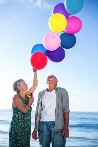 Senior couple holding balloons — Stock Photo, Image