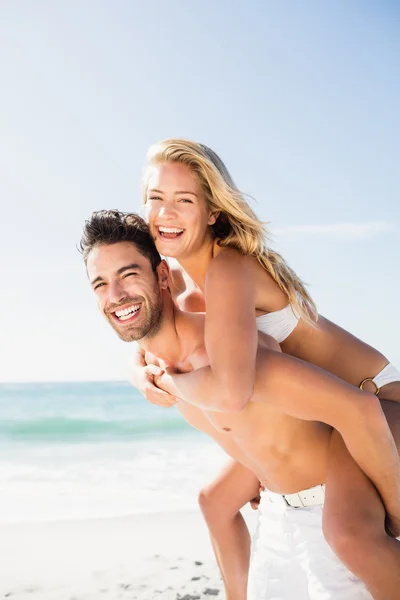 Boyfriend giving piggy back to girlfriend — Stock Photo, Image