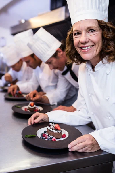 Equipo de cocineros terminando platos de postre — Foto de Stock