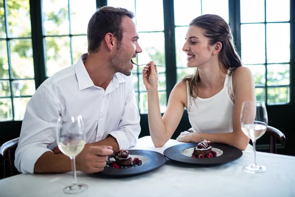 Couple feeding each other and smiling — Stock Photo, Image