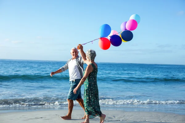 Casal sênior segurando balões — Fotografia de Stock