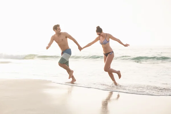 Casal feliz correndo na praia — Fotografia de Stock