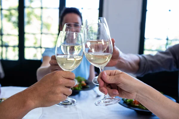 Freunde stoßen mit Weingläsern an — Stockfoto