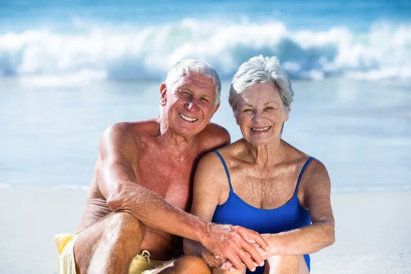 Carino coppia matura seduta sulla spiaggia — Foto Stock