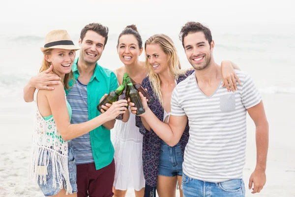 Groep vrienden roosteren bierflessen op het strand — Stockfoto