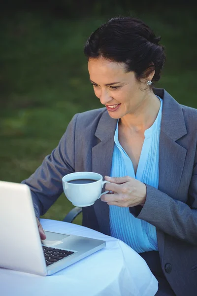 Ładna kobieta za pomocą laptopa i filiżankę kawy — Zdjęcie stockowe