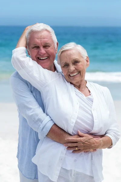 Coppia di anziani che si abbraccia in spiaggia — Foto Stock