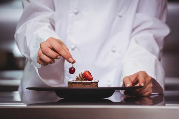 Koch setzt eine Kirsche auf ein Dessert — Stockfoto