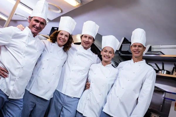 Equipe de chefs de pé na cozinha comercial — Fotografia de Stock