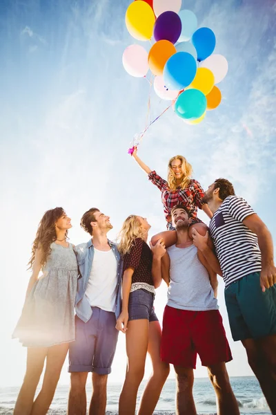 Φίλοι που ποζάρει με μπαλόνι στην άμμο — Φωτογραφία Αρχείου