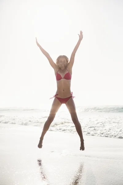 Glada kvinna i bikini hoppning — Stockfoto
