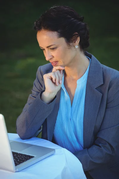 Mujer de negocios reflexivo utilizando el ordenador portátil —  Fotos de Stock