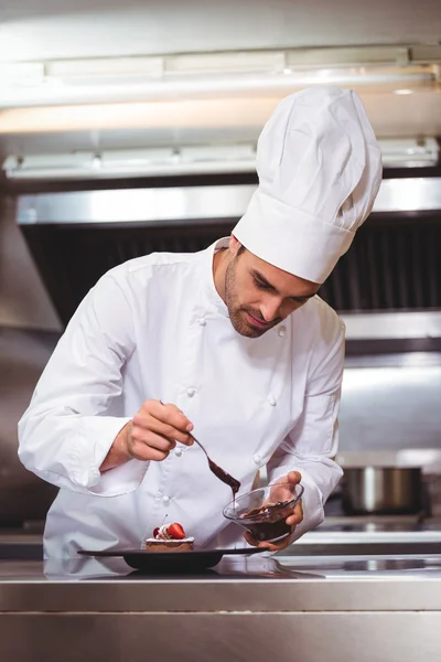 Chef pondo molho de chocolate em uma sobremesa — Fotografia de Stock