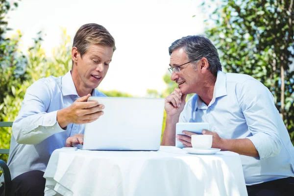 Dos hombres de negocios que se reúnen en un restaurante usando laptop —  Fotos de Stock