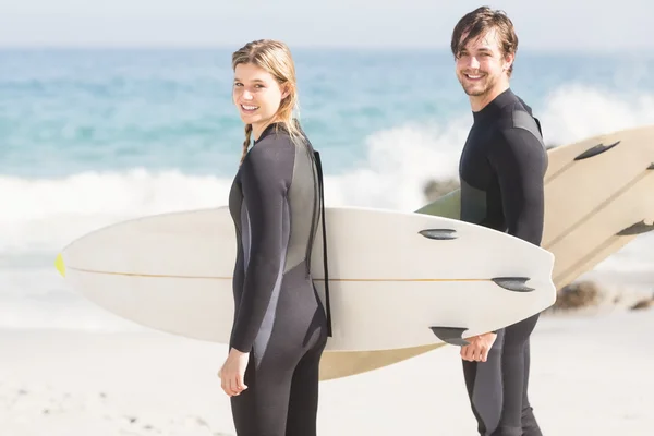 Portrait of couple with surfboard standing on the beach — Stock Photo, Image