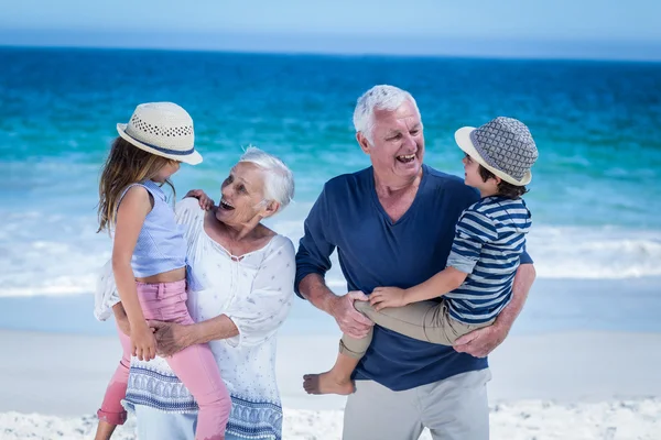 Nonni felici che ridanno maialino ai bambini — Foto Stock