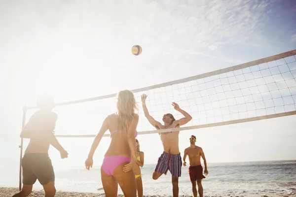 Amigos felizes jogando vôlei de praia — Fotografia de Stock