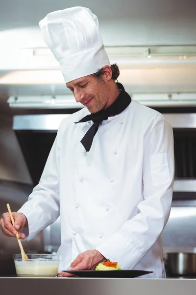 Koch legt Sauce auf einen Teller — Stockfoto