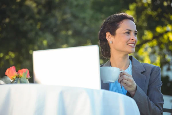 Бізнес-леді, використовуючи ноутбук з кавою — стокове фото