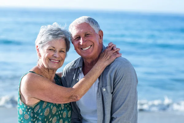 Senior paar omarmen op het strand — Stockfoto