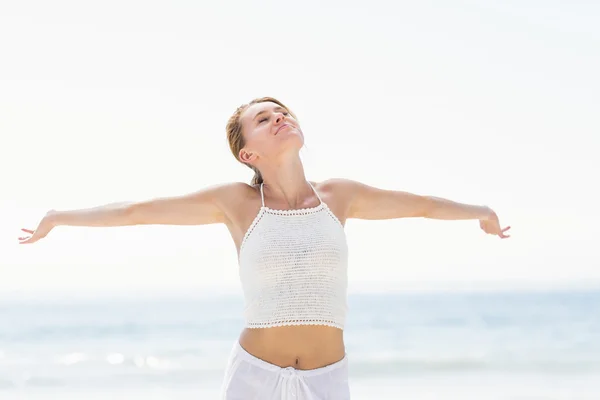 Vacker kvinna stretching hennes armar på stranden — Stockfoto