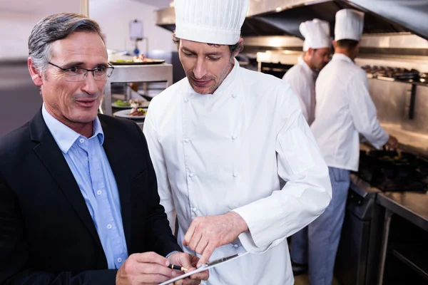 Restaurant manager writing on clipboard — Stock Photo, Image