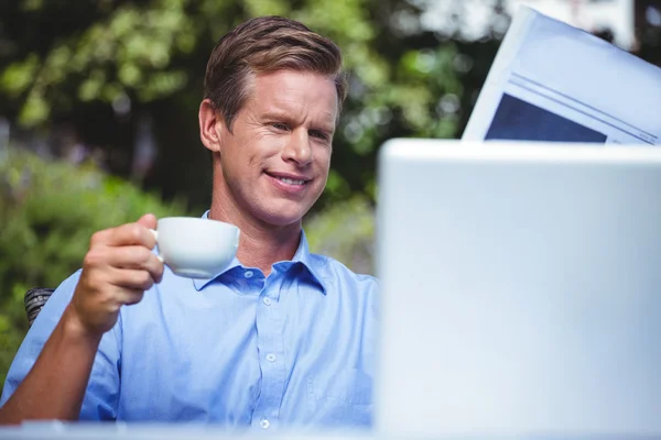 Businessman having coffee and reading the news — Stock Photo, Image