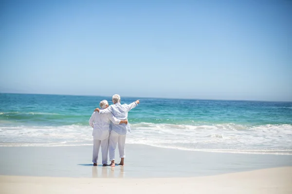 Äldre par embracing och pekar — Stockfoto