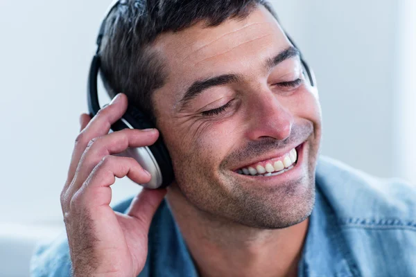 Jongeman die naar muziek luistert — Stockfoto