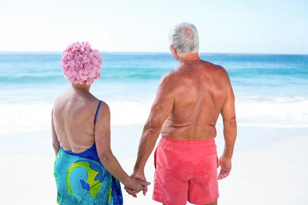 Linda pareja madura cogida de la mano en la playa — Foto de Stock