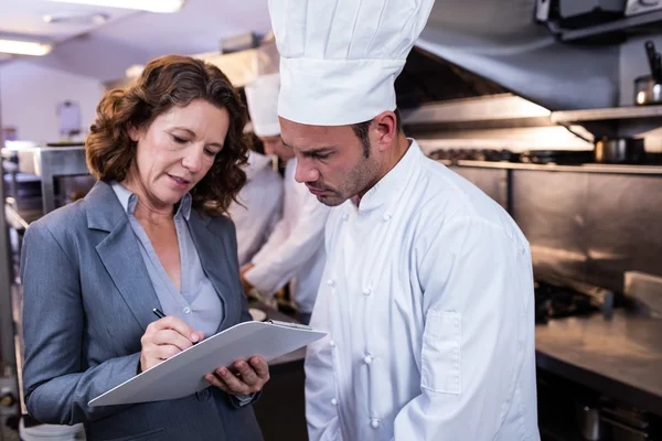 Restaurantleiter schreibt auf Klemmbrett — Stockfoto