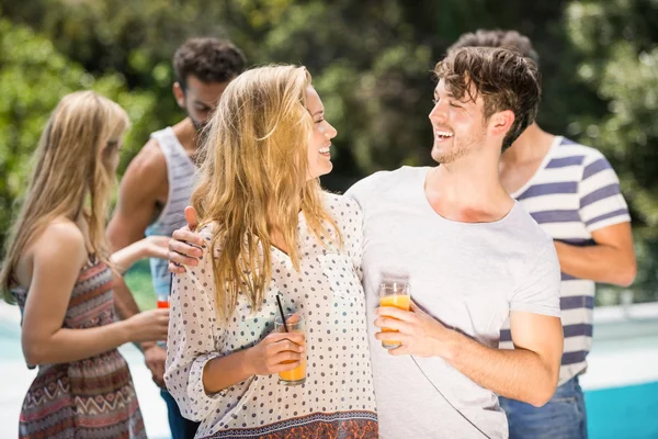 Casal jovem sorrindo e tomando suco juntos — Fotografia de Stock