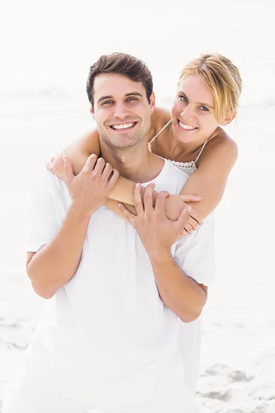 Man ger en piggy tillbaka till kvinnan på stranden — Stockfoto