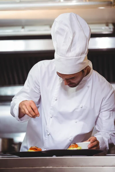 Chef-kok beregening specerijen op schotel — Stockfoto