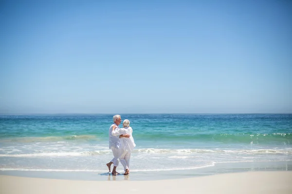 Äldre par embracing på stranden — Stockfoto