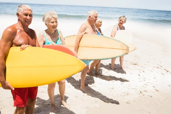 Старшие друзья держат доску для серфинга — стоковое фото